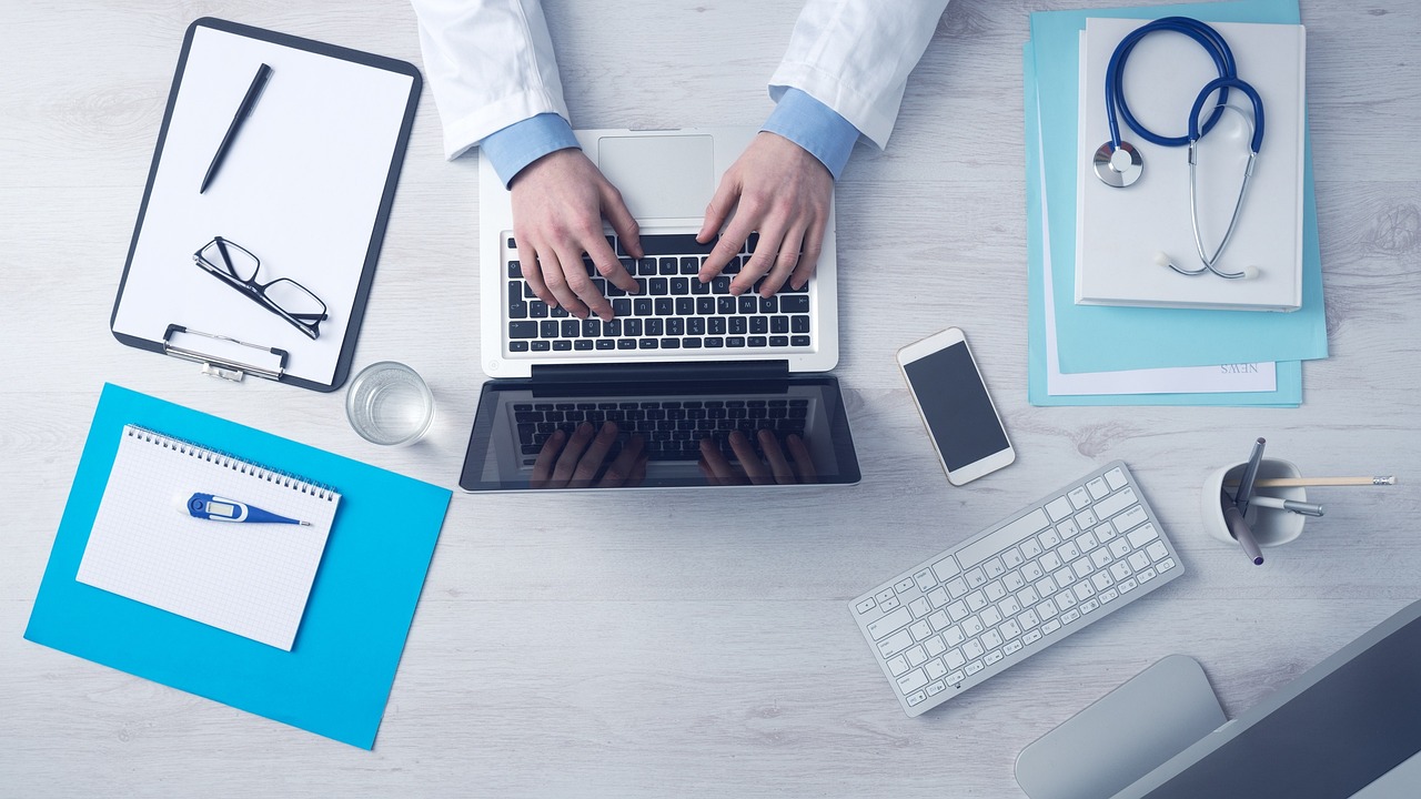 Como aplicar SEO para médicos na prática: escrivaninha com computador e anotações de planejamento do consultório