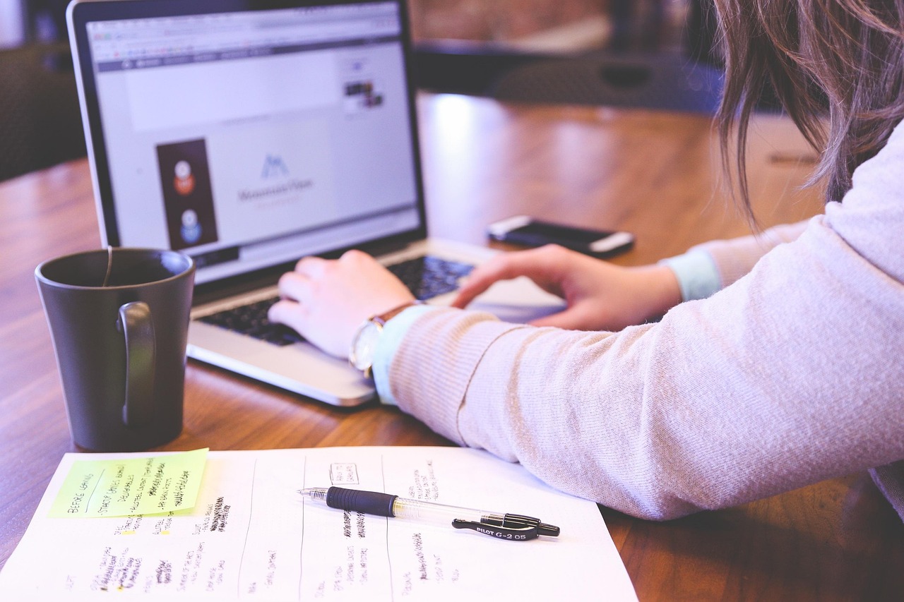 Empreendedora configurando hospedagem de sites com domínio no notebook, seguindo o passo a passo de contratação