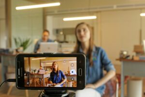 Marketing de influência exemplo: criadora de conteúdo gravando vídeo com smartphone para divulgar uma marca