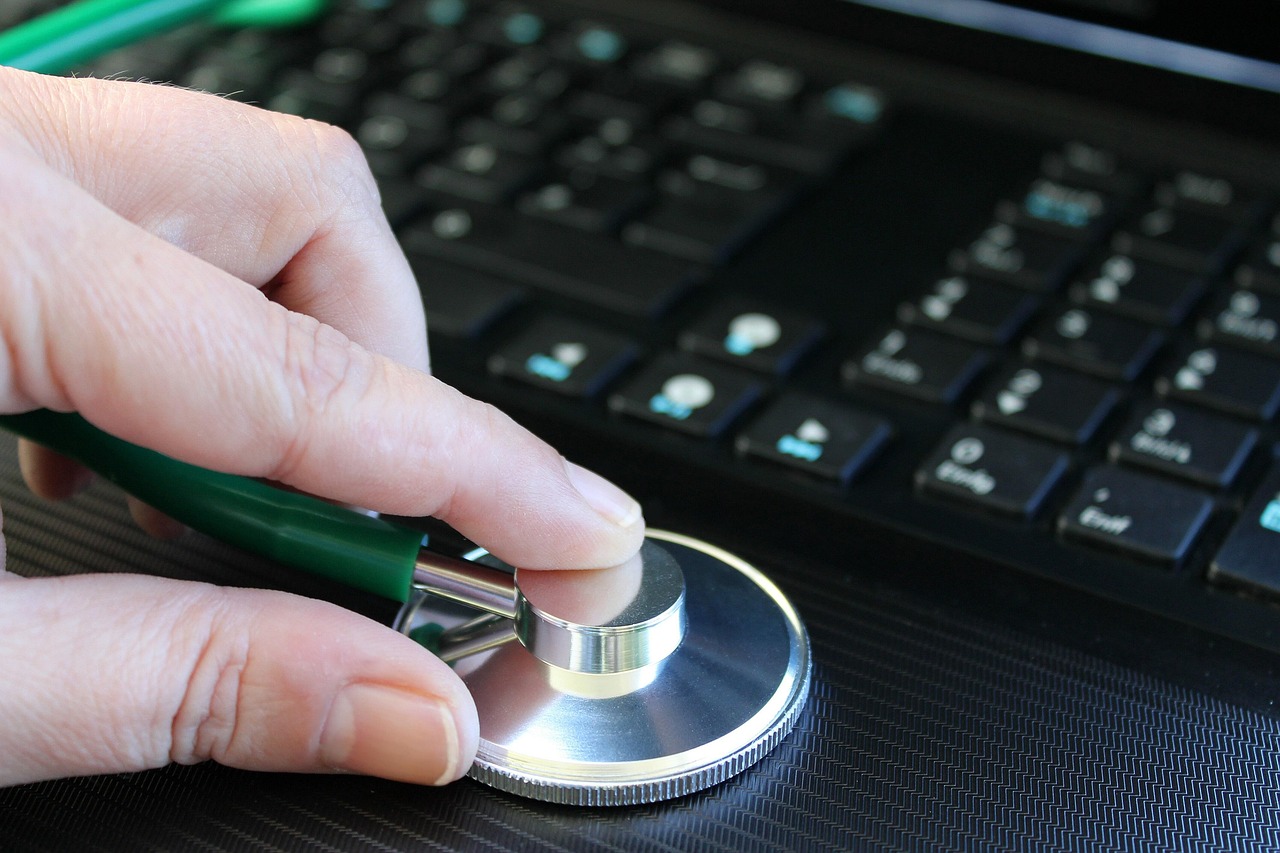 Serviços de SEO para médicos: estetoscópio e computador em consultório representando auditoria técnica e conteúdo